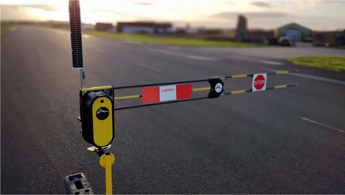 Solar powered barrier closed across a road in the evening light