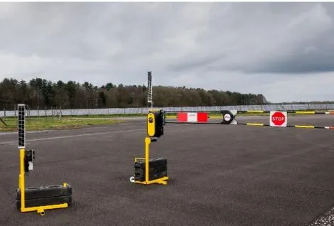 Auto-open vehicle sensor post beside two automatic traffic barriers