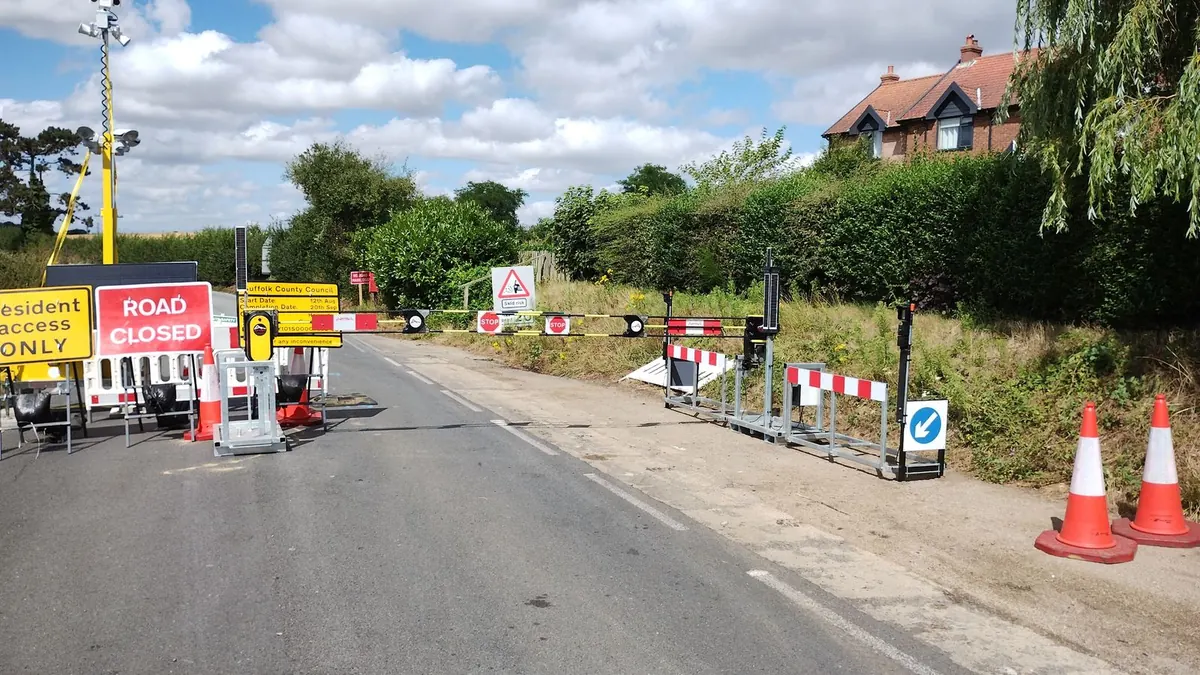 Automatic traffic barriers and road closed signs across a village road